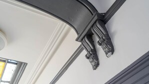 Un plafond orné d’une console décorative en métal et une fenêtre.