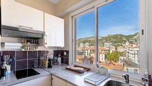 Una cocina moderna con un ventanal grande, electrodomésticos de acero inoxidable y vistas a la ciudad.