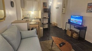 Un salon moderne avec un canapé, une table basse et un téléviseur.