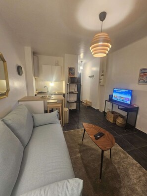 Ein modernes Wohnzimmer mit einer Couch, einem Couchtisch und einem Fernseher.