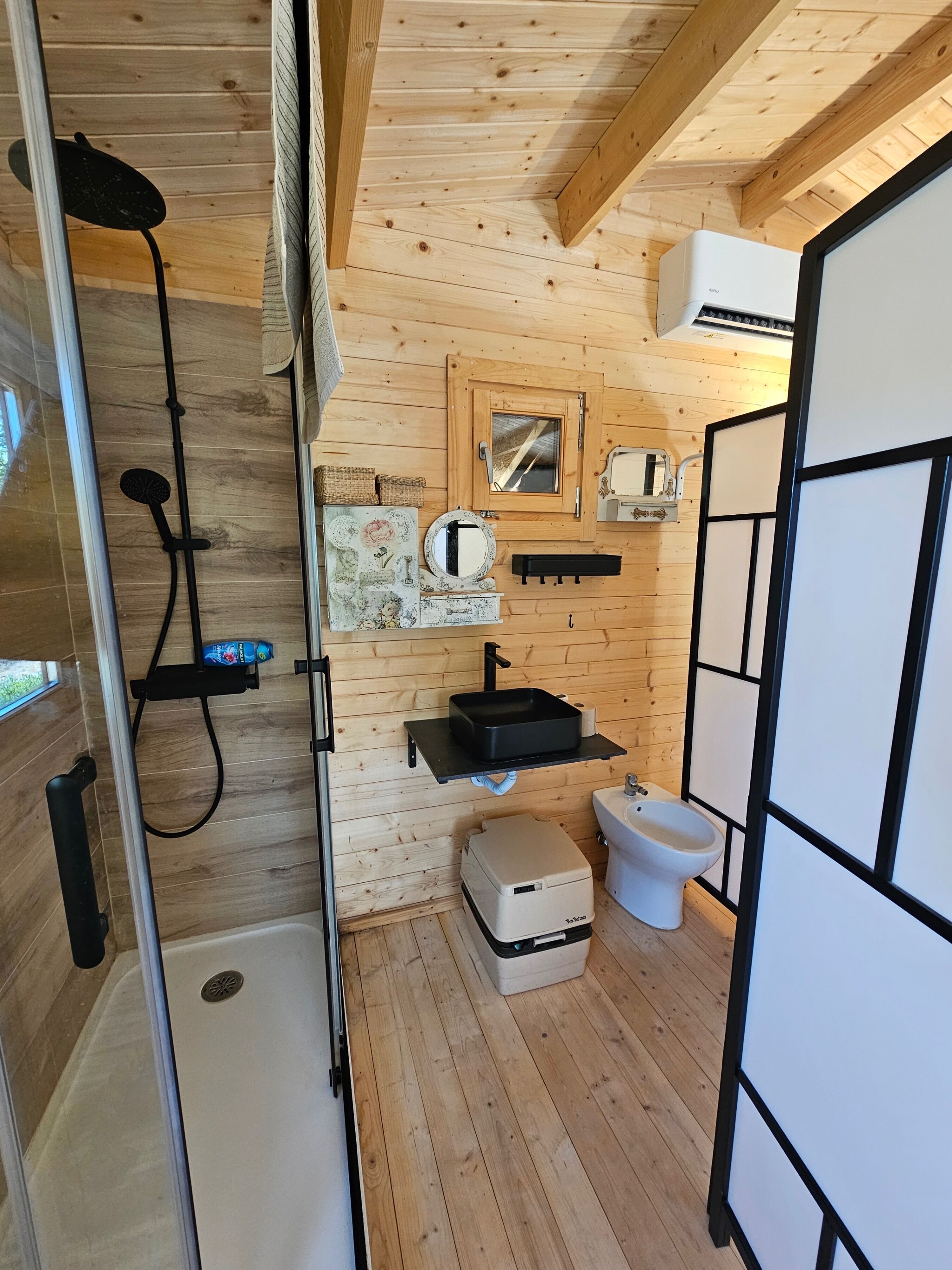 A compact bathroom with a shower, toilet, and sink.