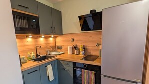 A compact kitchen with a sink, stove, and refrigerator. - Joli studio • 5 min plages • Tout à pied (Saint-Mandrier-sur-Mer)