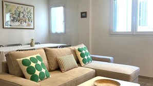 A living room with a sofa, a coffee table, and a painting on the wall. - Joli T3 spacieux & climatisé – confort + wifi (Toulon)