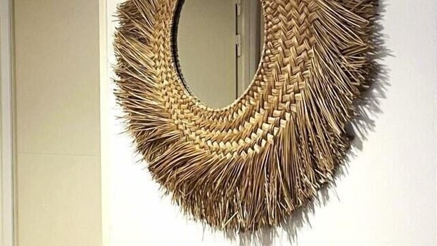 A circular woven mirror with a fringed edge on a plain wall. - Joli T3 spacieux & climatisé – confort + wifi (Toulon)