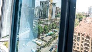 Ein Hochhaus mit Blick auf eine Stadtlandschaft durch ein Fenster.