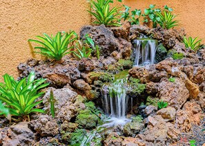 A small waterfall surrounded by rocks and green plants. - Maui Vista #2-218 Close to Beach, Pickleball Courts, Full A/C (Kihei)