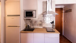 Cocina con horno empotrado, microondas y campana extractora de acero inoxidable.