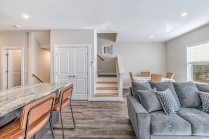 Un interior moderno con una zona de cocina, una escalera y un área de estar.