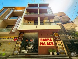 Un edificio de varios pisos con un letrero que dice Radha Palace Hotel.