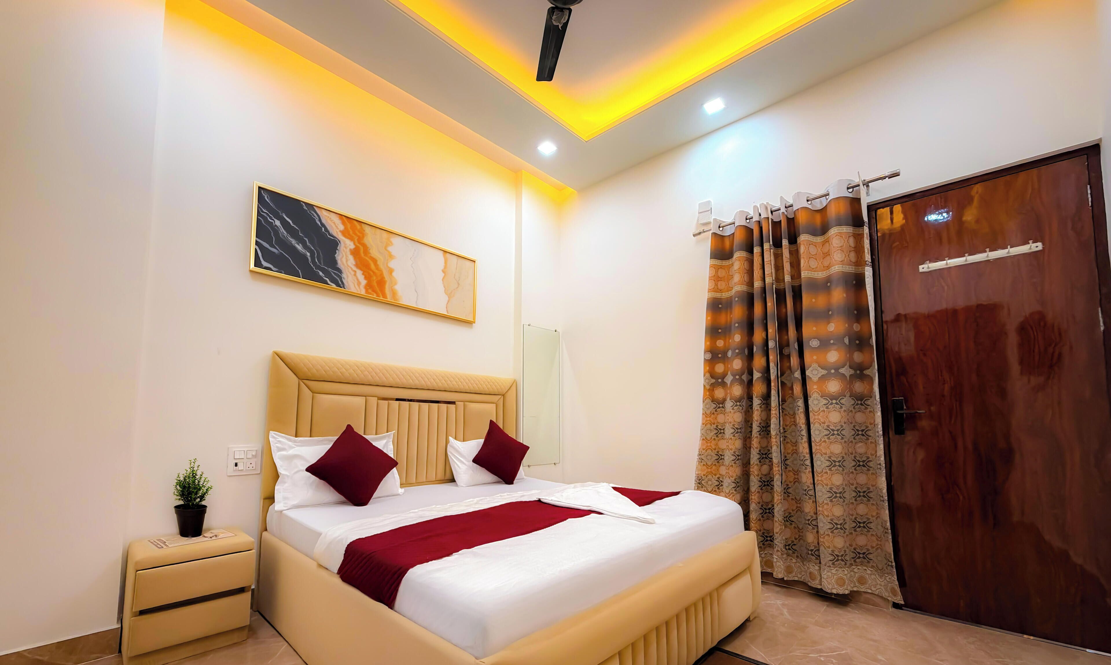 A hotel room with a bed, bedside table, and a mirror.