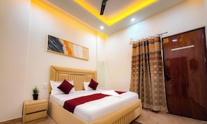 Quarto de hotel com cama, mesa de cabeceira e espelho.