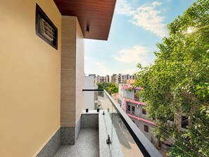 A residential building with a balcony, a view of the street, and neighboring buildings. - Radha Palace – Near Prem Mandir and ISKCON (Vrindavan)