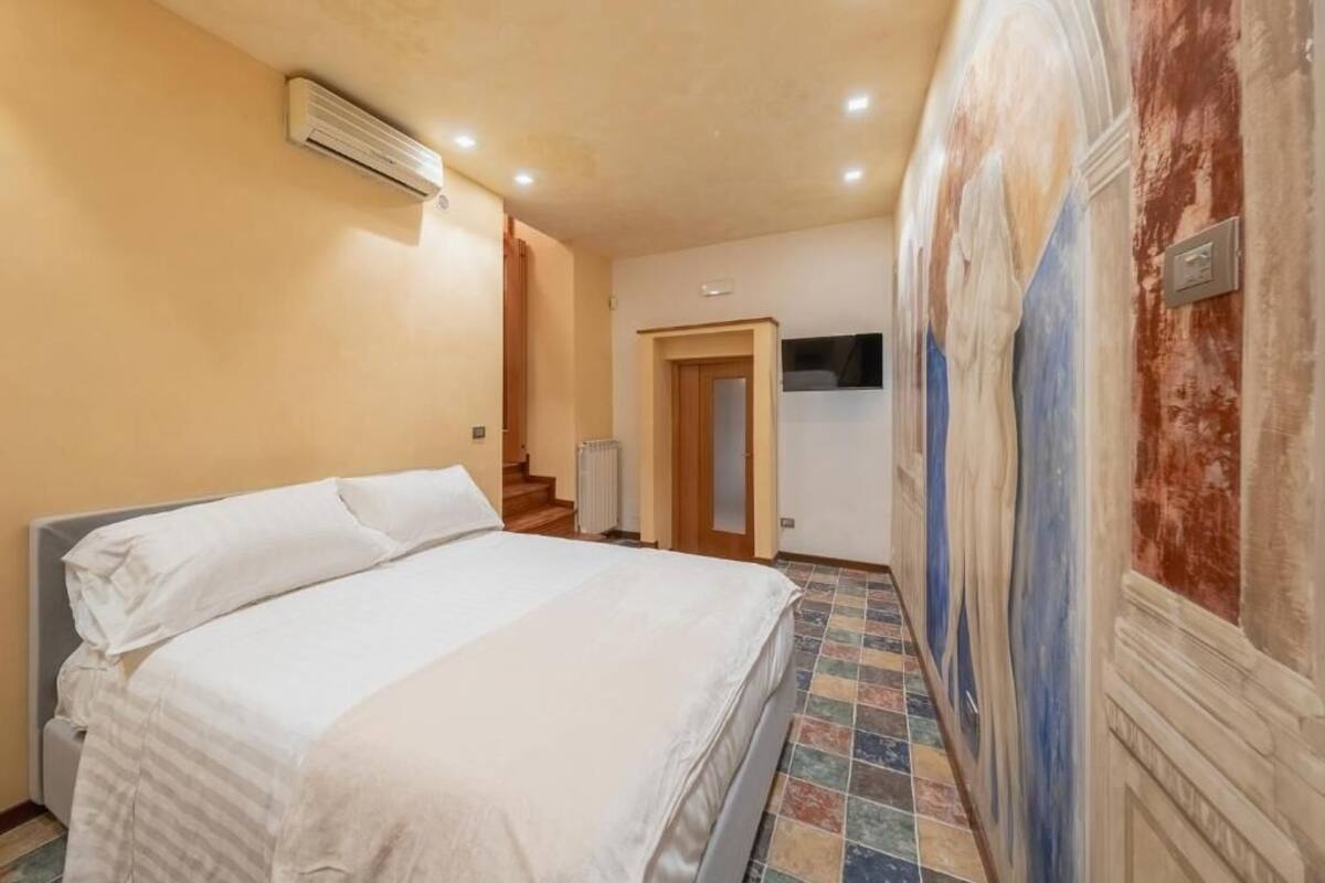 Ein Schlafzimmer mit Bett, Klimaanlage, einer Tür und Fliesenboden.