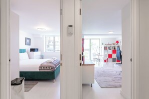 A modern bedroom with a bed, bedside table, and a window. - Cosy Canalside Retreat in the Heart of West London (London)