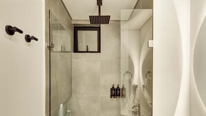 Ein modernes Badezimmer mit Duschkabine aus Glas, einem Spiegel und einem Handtuchhalter.