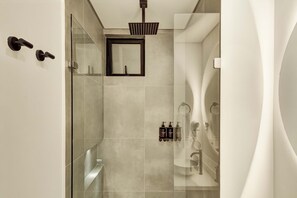 Ein modernes Badezimmer mit Duschkabine aus Glas, einem Spiegel und einem Handtuchhalter.