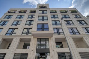 A multi-story building with a symmetrical facade, large windows, and balconies with plants. - w Bright 1BR Near to the Center of Milan (Milan)