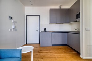 A modern kitchen with grey cabinets, a white countertop, and a wooden floor. - w Bright 1BR Near to the Center of Milan (Milan)