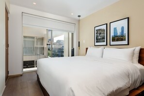 A hotel room with a large bed, a sliding glass door to a balcony, and two framed pictures on the wall. - w Deluxe 2BR w Private Terrace in Hipodromo (Mexico City)