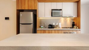 A modern kitchen with a built-in microwave, stainless steel refrigerator, and wooden cabinetry. - w Deluxe 2BR w Private Terrace in Hipodromo (Mexico City)