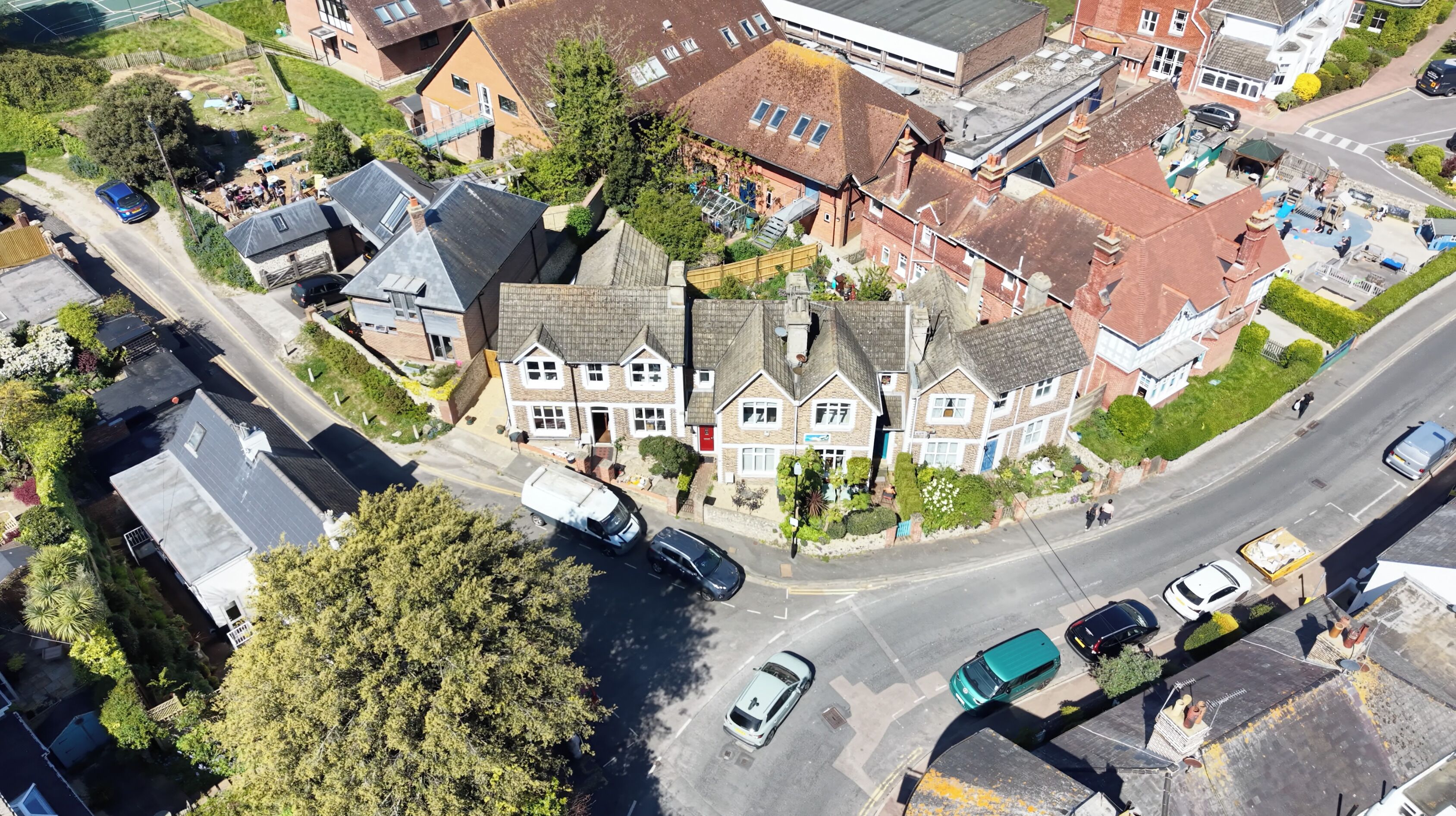 An aerial view of a residential area with houses, a road, and a parked tanker truck.