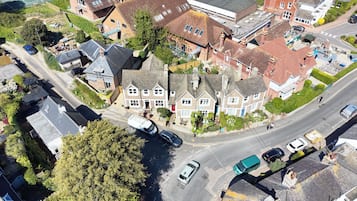 An aerial view of a residential area with houses, a road, and a parked tanker truck.