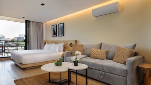 Ein Hotelzimmer mit einem Bett, einer Couch, einem Couchtisch und einer Klimaanlage.