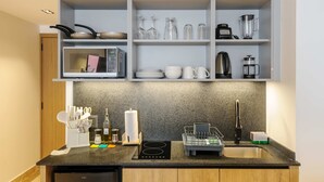 A kitchen with a built-in microwave, a coffee maker, a kettle, and a dish rack. - w Stylish Loft w/ Balcony in Parque Mexico (Mexico City)