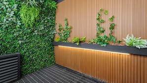A modern interior with a vertical garden, wooden panel wall, and a black metal bench. - w Airy Loft W/balcony in Parque Mexico (Mexico City)