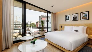 A hotel room with a large bed, a small table, a potted plant, and a balcony with a view of the city. - w Airy Loft W/balcony in Parque Mexico (Mexico City)