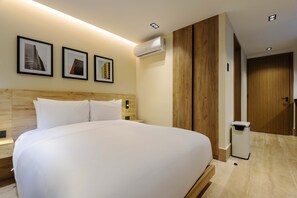 A hotel room with a large bed, a wooden headboard, a wall-mounted air conditioner, and framed pictures on the wall. - w Swish Loft W/balcony in Parque Mexico (Mexico City)