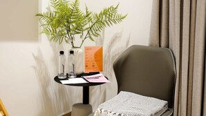 A room with a black chair, a small table with a plant, two bottles, and a welcome card. - w Swish Loft W/balcony in Parque Mexico (Mexico City)