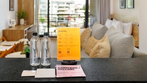 Una recepción con un letrero de bienvenida, dos botellas de agua y una tarjeta para huéspedes.
