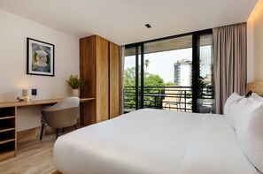 A modern hotel room with a large bed, a desk, a chair, a potted plant, and a balcony with a view of the city. - w Designer Loft W/balcony in Parque Mexico (Mexico City)