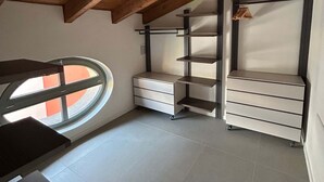 A room with a sloped ceiling, a window, and built-in shelving units. - w Luxury 5BR Retreat Near Navigli (Milan)