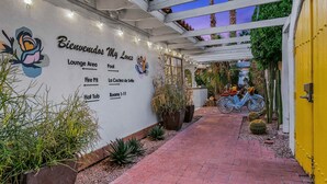 Ein Hotel Eingang mit einem Schild, das eine Lounge, einen Pool und Zimmer 1 bis 11 anzeigt.