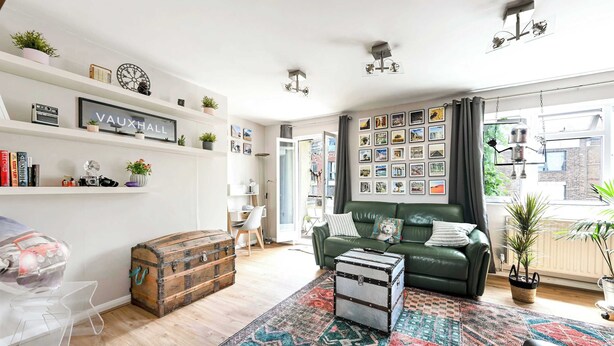 A living room with a green sofa, a vintage trunk, and a patterned rug. - The Explorer's Home (Greater London)
