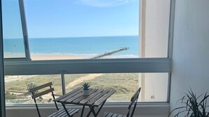 Un balcón con vista a la playa y al muelle.