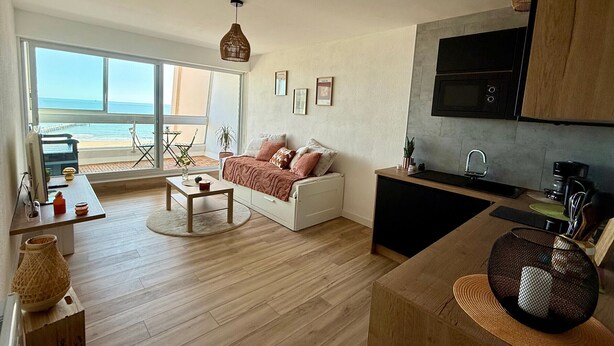 Un espacio habitable moderno con sofá, mesa de centro y comedor.