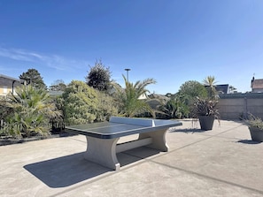 A pool table in an outdoor patio area with surrounding greenery and a clear sky. - Mobile home with parking, pets welcome - 4 guests near beach (Jullouville)