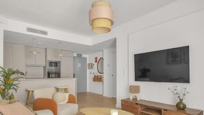 Una sala de estar moderna con un sofá, una mesa de centro, un televisor y un mueble de madera.