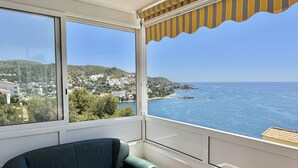 Un balcón con vista al mar y un sofá verde.