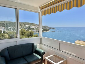 Ein Balkon mit Blick auf das Meer und einem grünen Sofa.