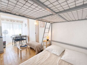 A compact room with a bed, a small table, a chair, a desk, and a ladder. - Peaceful studio near beach - 4 guests (Narbonne)