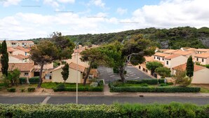 Un barrio residencial con casas, una calle y una colina al fondo.