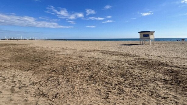 Una playa con una torre de salvavidas y un cielo despejado.