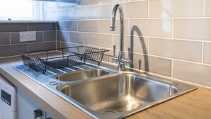 Een moderne keuken met roestvrijstalen apparatuur, een dubbele spoelbak en een houten aanrecht.