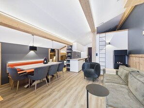 A modern kitchen with a dining area, a sofa, and a small table. - Studio with piste view in center, 6 guests (Les Gets)