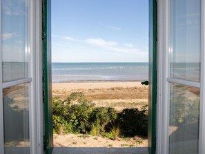 An open door with a view of a beach and ocean. - Family house with beach access - 8 guests (Les Portes-en-Ré)