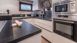 Una cocina moderna con microondas, horno y cafetera incorporados.